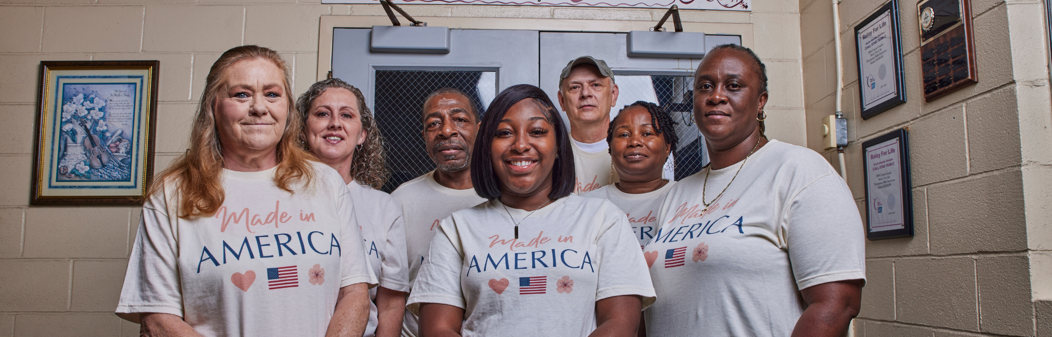 Group of people wearing 'Made in America' t-shirts in a classroom setting.