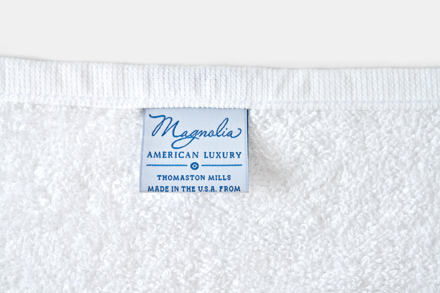 Label on a white fabric with 'Magnolia American Luxury' text