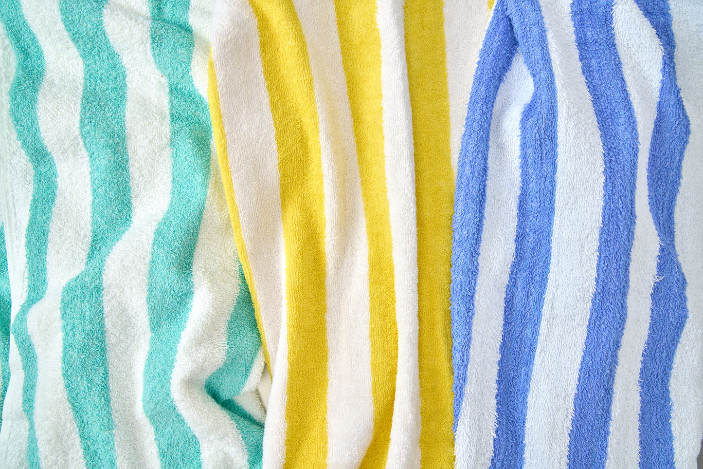 Stack of colorful striped towels in turquoise, yellow, and blue.