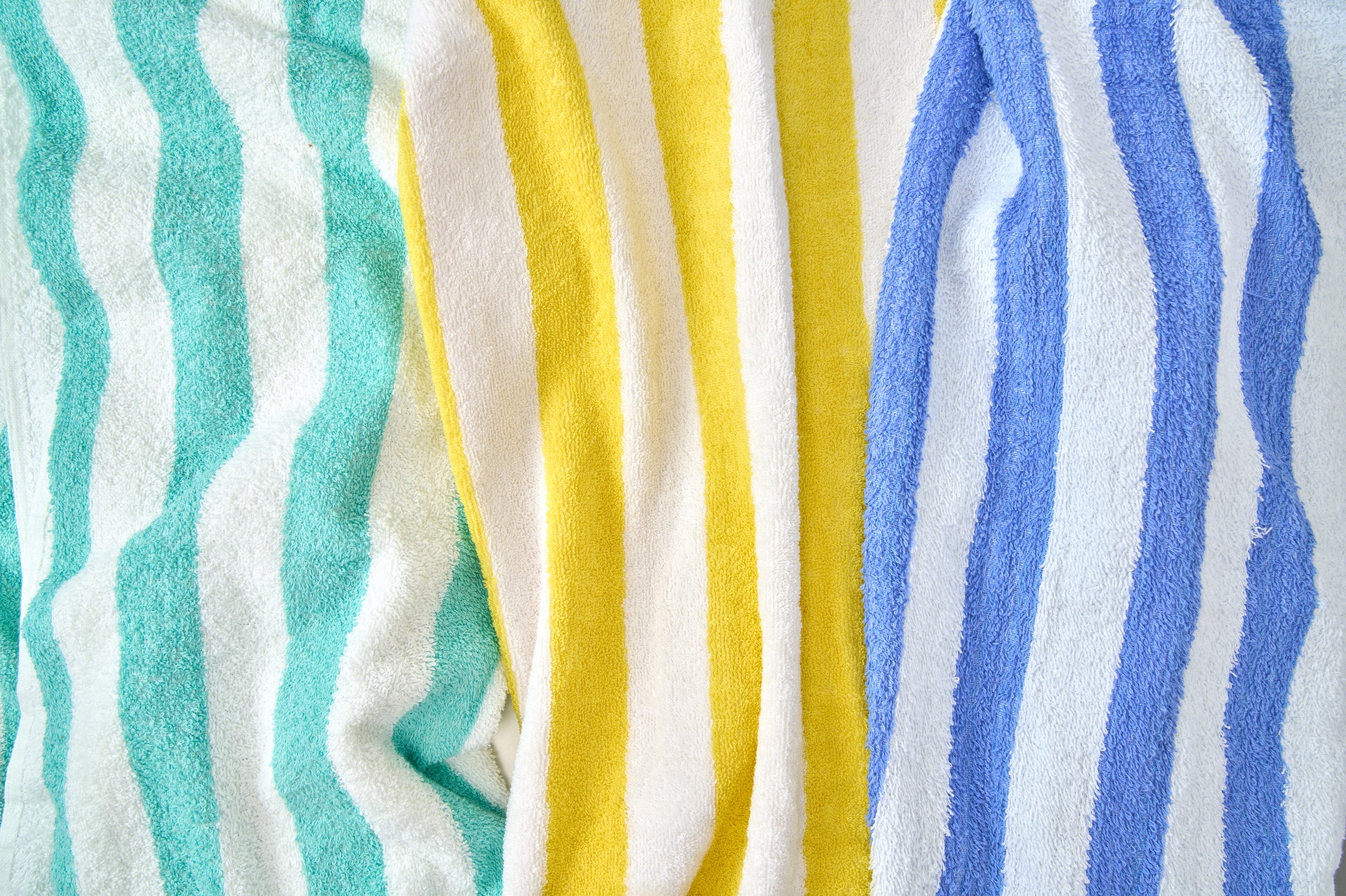 Stack of colorful striped towels in turquoise, yellow, and blue.
