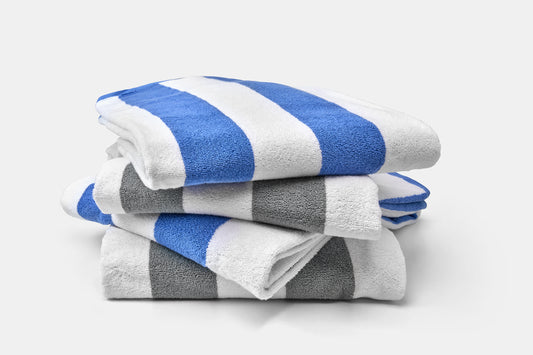 Stack of blue, gray, and white striped towels on a light gray background