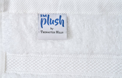 Label with 'TM Plush by Thomaston Mills' on a textured white fabric background