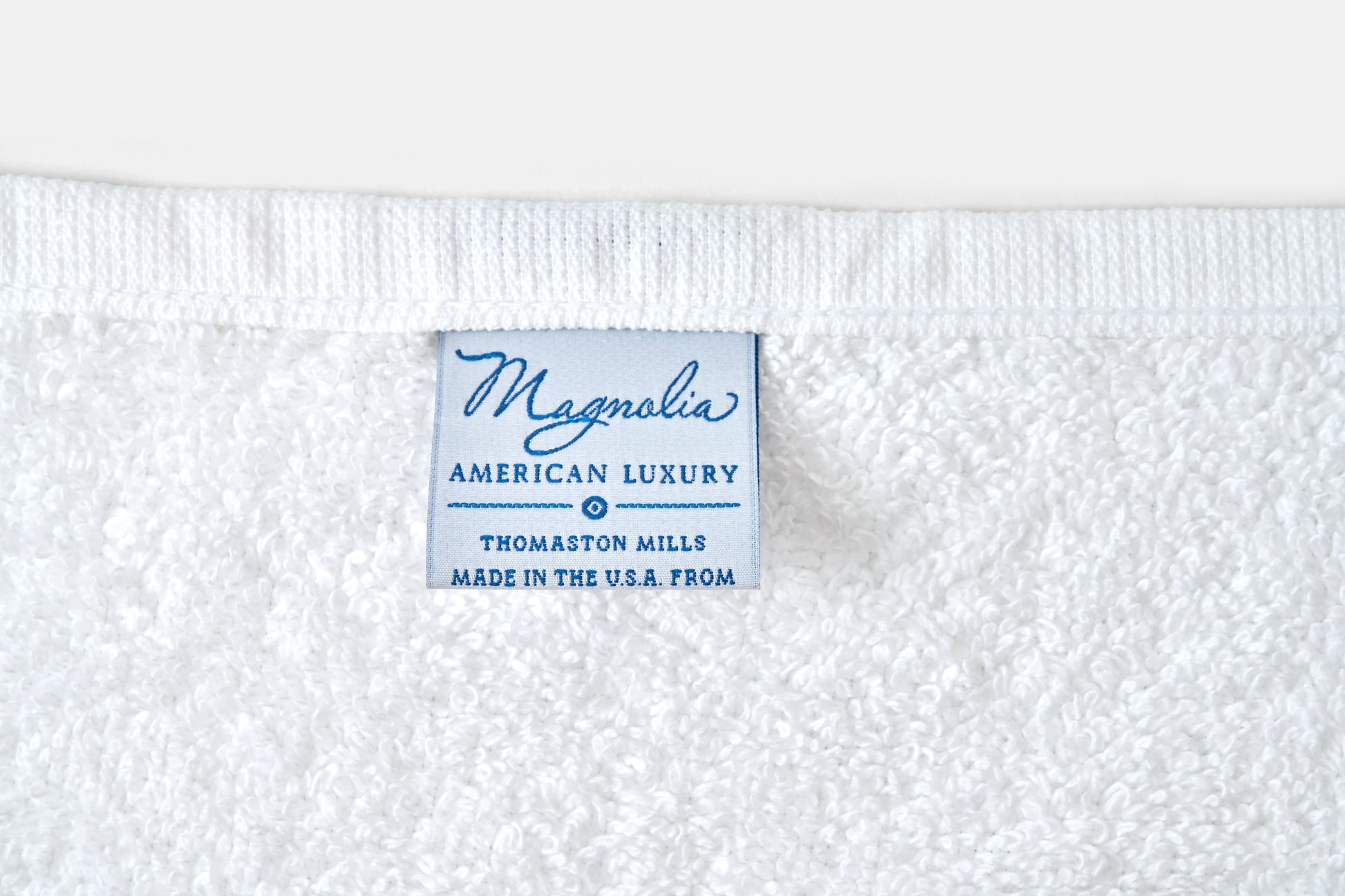 Label on a white fabric with 'Magnolia American Luxury' text
