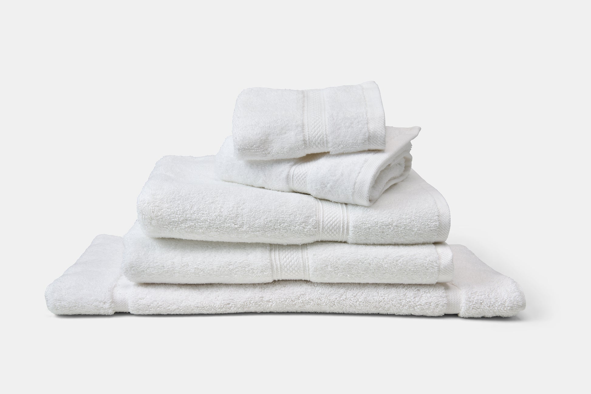 Stack of white towels on a light gray background