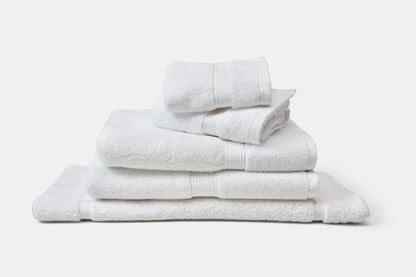 Stack of white towels on a light gray background
