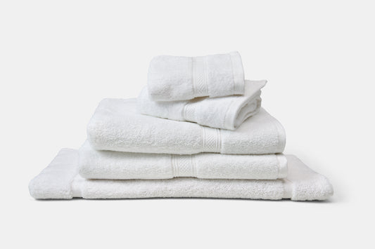 Stack of white towels on a light gray background