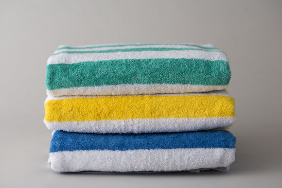 Green, Yellow and Blue Island stripe pool towels folded and stacked. Thomaston Mills Towels.