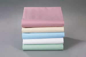 Thomaston Mills Pastel Sheets in Bone, Light Blue, Seafoam Green and Rose folded and stacked.
